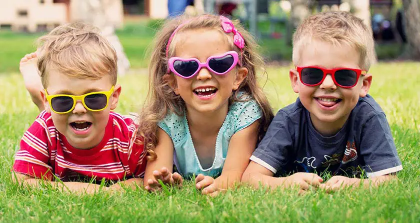 Drei lachende Kinder mit Sonnenbrillen